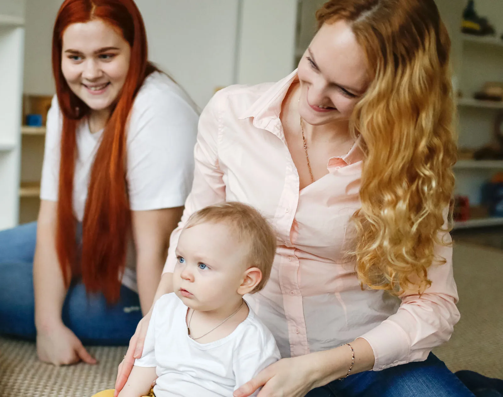 Begleiterin mit Mutter und Baby PEKiP-Begleiterin und Mutter spielen mit einem Baby