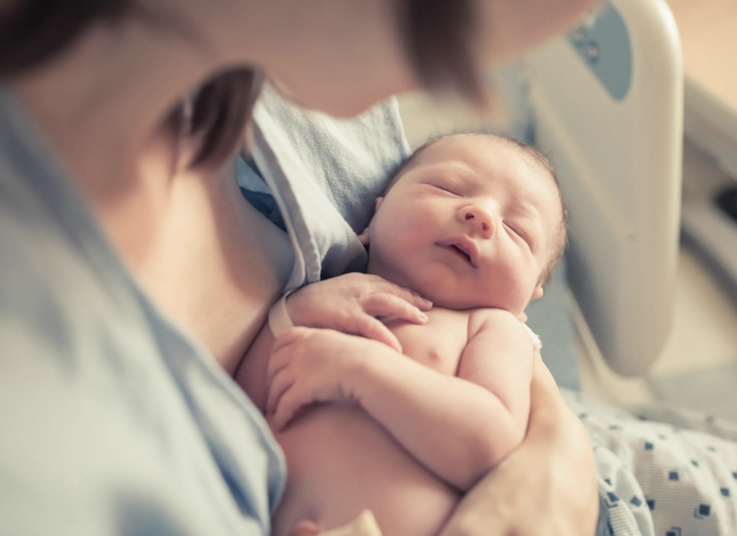 Mutter hält ihr schlafendes Neugeborenes im Arm