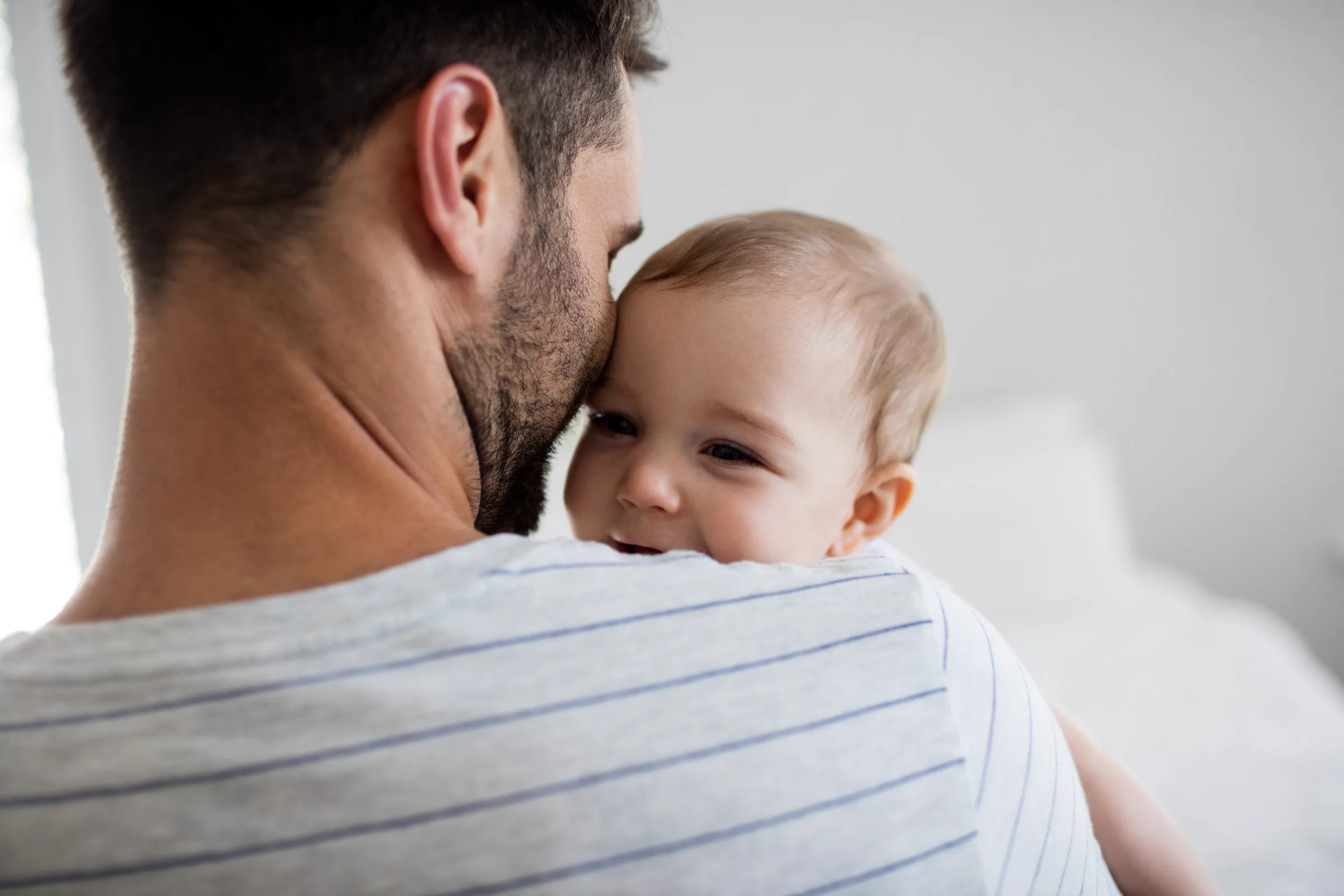 Vater hält sein lächelndes Baby im Arm
